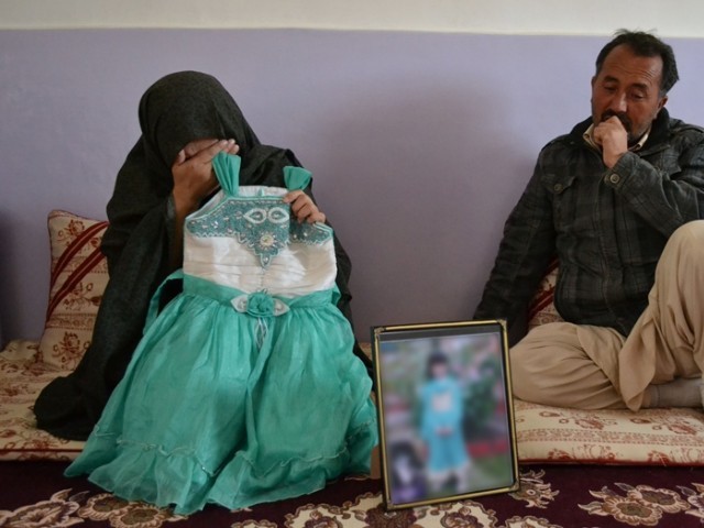 Bakhtawar, the mother of Sahar Batool, who was from the Hazara community and found dead at a garbage dump, shows a photograph of her late child in Quetta on November 7, 2014. PHOTO: AFP